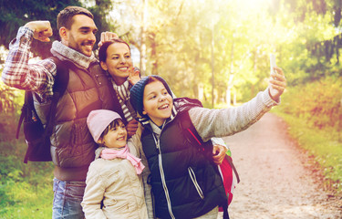 family with backpacks taking selfie by smartphone