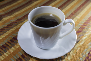 Black Coffee in White Cup on Colorful Napkin