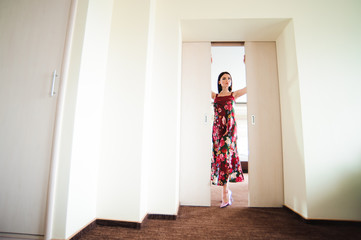 Young woman opening door at modern hotel room