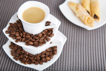 Morning cup of espresso and cake arranged on a gray background. 