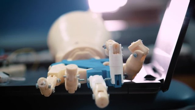 Futuristic robotic cyborg arm in action. Real robotic prosthesis. modern medical technologies in limb prosthetics. The android's hand moves with mechanical fingers in test mode.