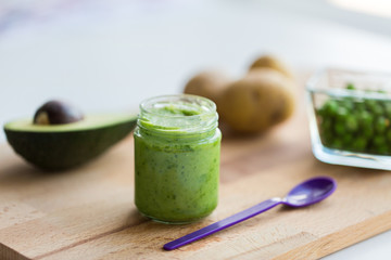jar with puree or baby food on wooden board