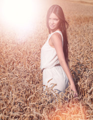 Woman with beauty long brown hair posing in a field