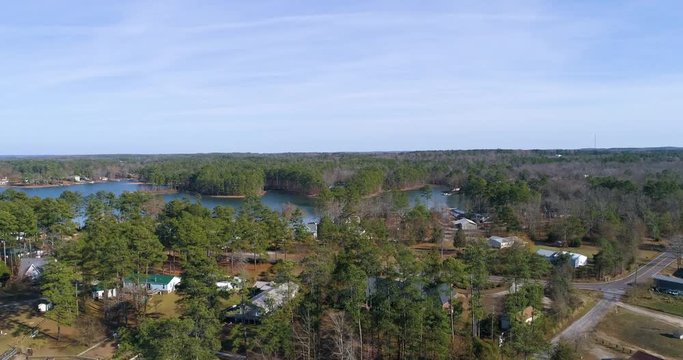 Aerial drone footage over a lake neighborhood in the forest