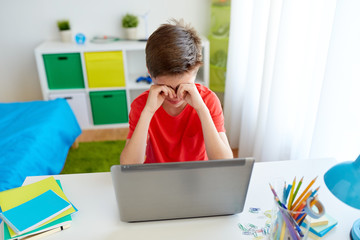 tired student boy with laptop computer at home