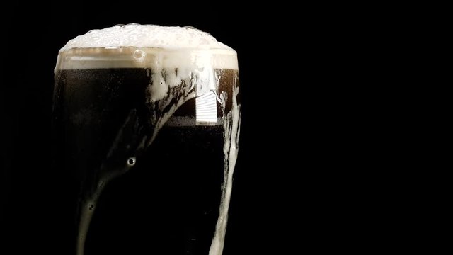  Hand takes a pint of beer. Stout, dark ale or porter
