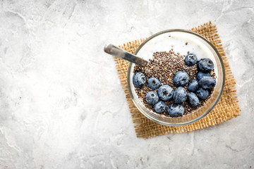How to eat chia seeds. Dessert with yogurt, chia and blueberries on grey background top view copyspace