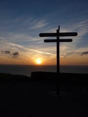 Wegweiser vor Meer bei Sonnenuntergang an Nordsee Normandie