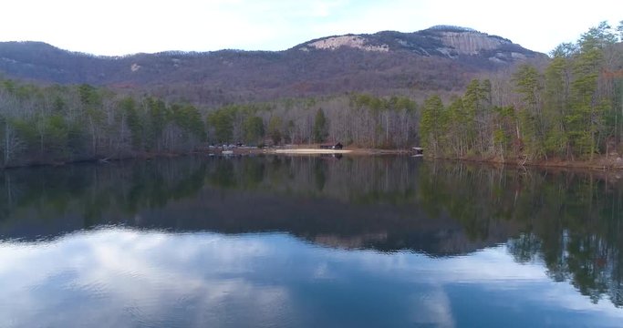 Aerial drone footage over a lake with a mountain
