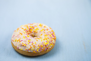 One donut  on a wooden background.