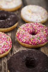 Multicolored donuts  on a wooden background.
