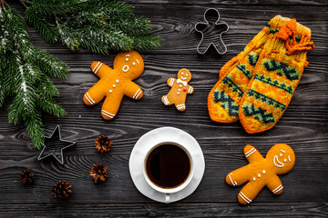 Cozy christmas evening. Coffee, cookies, spruce branch, knitten mittens on grey wooden background top view
