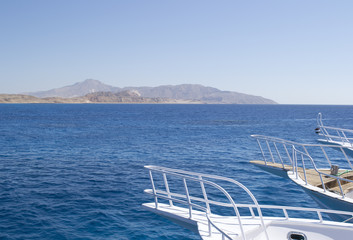 Fototapeta premium parts of yachts against a background of blue water and islands