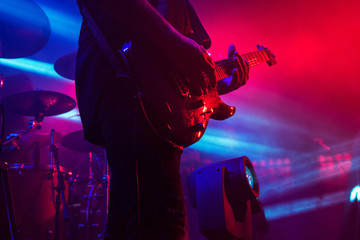 Guitar in the hands of a musician on a rock concert music