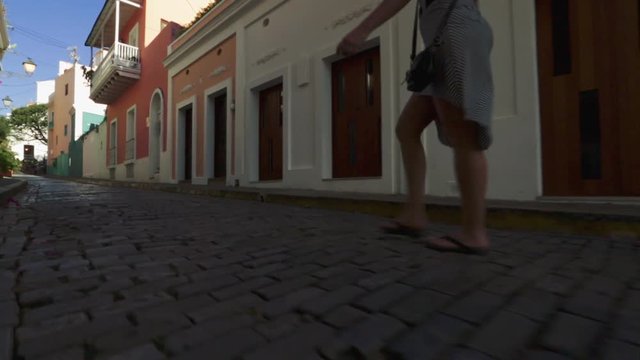 Woman walking on cobblestone streets in Old San Juan, Puerto Rico.