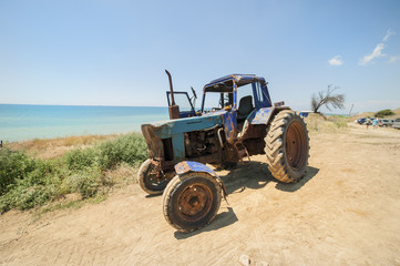 An old tractor standing on the seashore