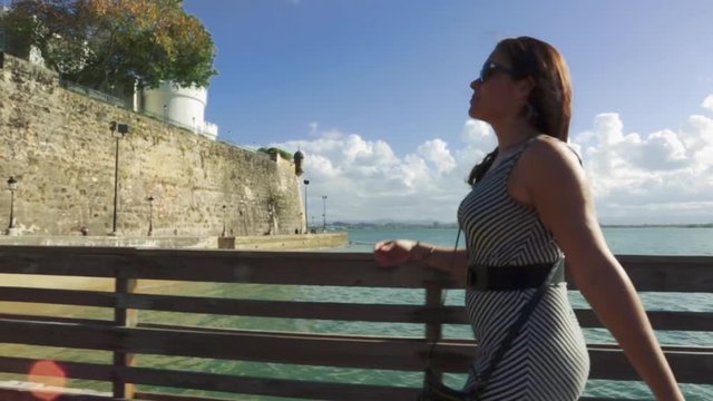 Woman walking and smiling on a pier in San Juan, Puerto Rico