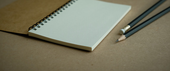 open spiral notebook with two black pencils