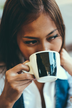 Close-up portrait of beautiful young woman holding cup of tea or coffee, Selective Focus.