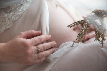 Pregnant girl hugging her belly