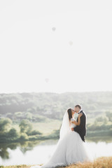 Newly married couple running and jumping in park while holding hands