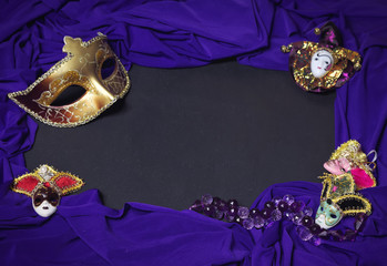 Colorful Mardi Gras or Carnival masks as frame on blackboard