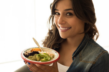 Woman eating a vegan bowl