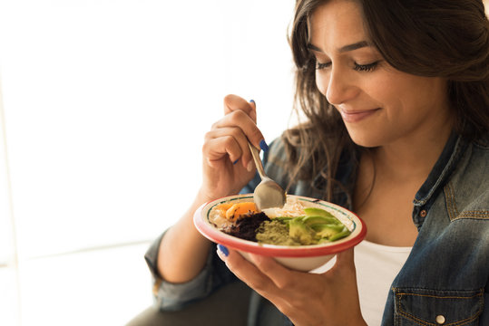 Woman eating a vegan bowl