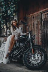 Fototapeta na wymiar Young girl bride on a new man's motorcycle. Waiting for his prince