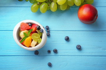 Naklejka na ściany i meble Dish with delicious fruit salad on wooden table