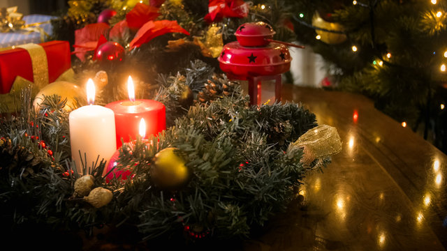 Closeup image of burning candles and Advent wreath at living room