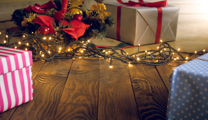 Beautiful Christmas background with lights, gifts and Christmas tree on wooden flory. Copy space for your text or design