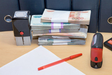 Russian money, clean sheet of paper, pen, print on table. Tax and other financial liabilities of a legal entity