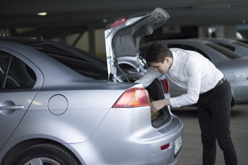 man repairing his car on the phone