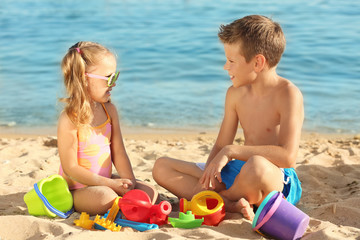 Cute little children playing on sea beach