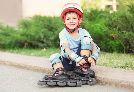 Little boy on roller skates in summer park