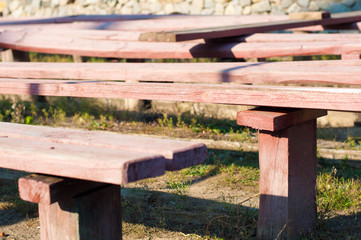 Old pink wood benches on sunny afternoon