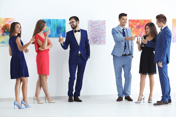Group of people in formal wear at art gallery exhibition
