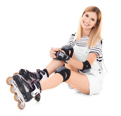 Attractive woman with roller skates against white background