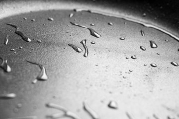 Drops of oil in a teflon frying pan close up.