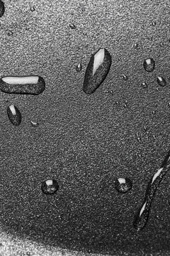 Drops of oil in a teflon frying pan close up.