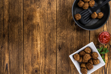 Fototapeta na wymiar Meatballs on an old wooden table (selective focus)