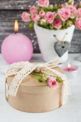 Pink roses in concrete pot with candle