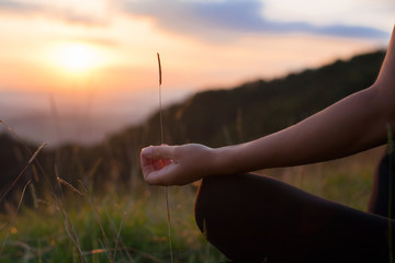 Woman doing yoga meditation in the mountains at dawn