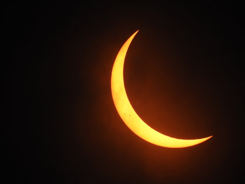 Crescent sun with sunspots
