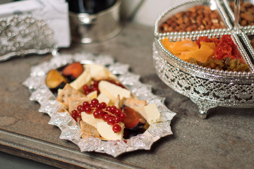 Cheese with appetizers on a silver plate.