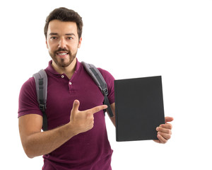 Student points to the black book cover. Beautiful and bearded person. He is wearing a magenta polo shirt.
