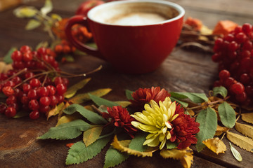 Obraz na płótnie Canvas Cup of hot latte on the autumn background. Fall bouquet on the wooden rough surface.