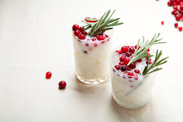 Perfect christmas cocktail: coconut margarita with cranberries and rosemary. Minimalistic concept. Linen cloth and white background. Horizontal composition with copy space.