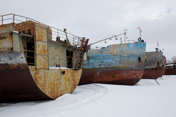 large rusty barges in winter backwater